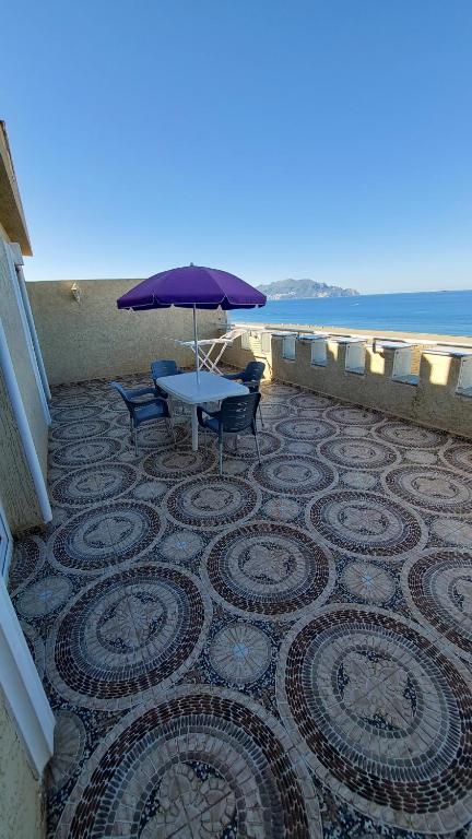 une terrasse avec une table, des chaises et un parasol dans l'établissement Hotel Blador, à Tichi