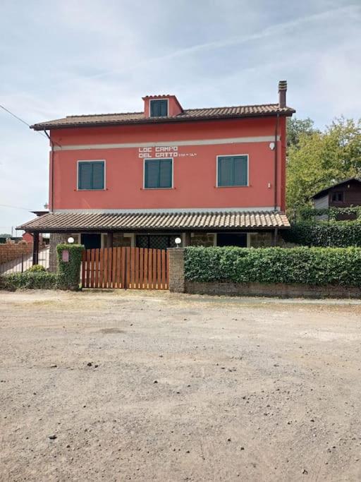 una casa roja con una valla delante en Campo del Gatto, en Viterbo