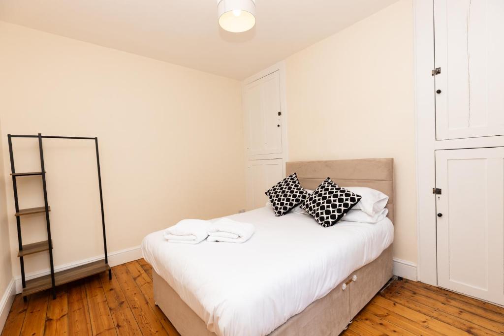 una camera da letto con un letto con cuscini bianchi e neri di The Limes a Harston