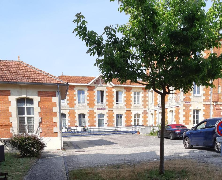 um edifício com um carro estacionado num parque de estacionamento em Appt plein coeur de Soulac sur Mer em Soulac-sur-Mer