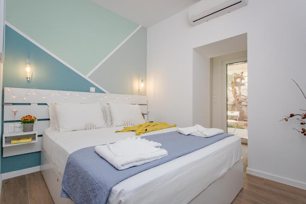 a bedroom with a large white bed with towels on it at Little gem by the sea in Chania