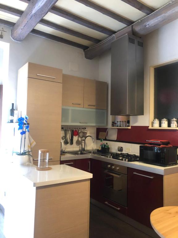 a kitchen with wooden cabinets and a stove top oven at Vacanza in Chianti in Badia A Passignano