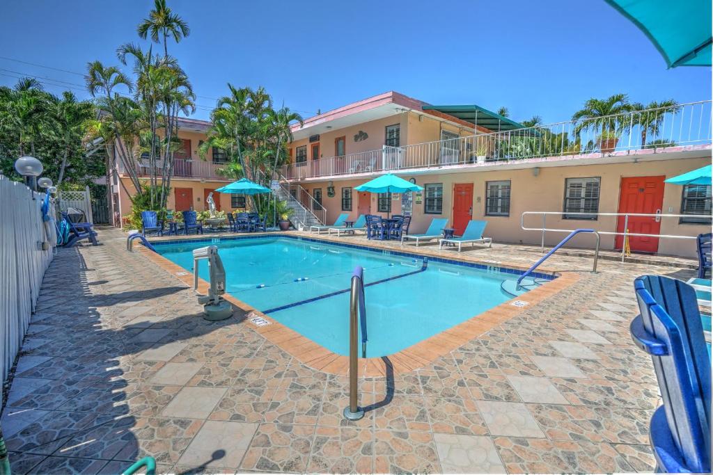 una piscina en un complejo con sillas y sombrillas en Sea Garden by the Sea, en Fort Lauderdale