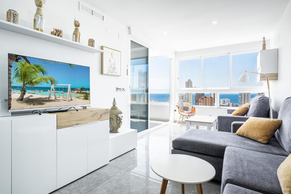 uma sala de estar com uma televisão e um sofá em Gemelos 22-3-21D Apartment Deluxe Levante Beach em Benidorm
