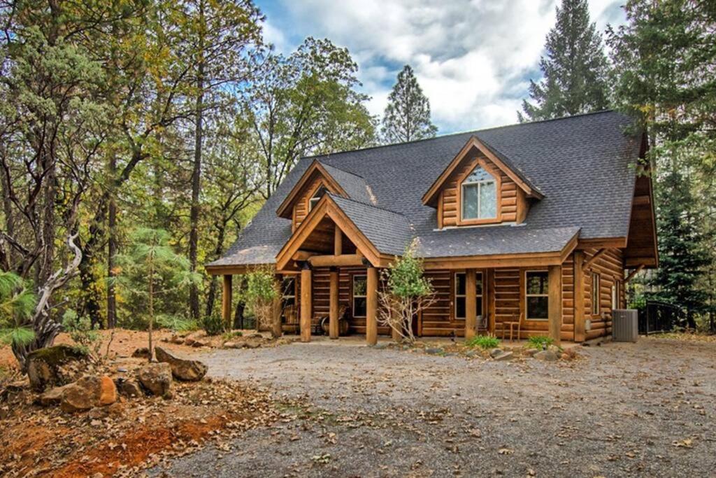 a log cabin in the woods with a yard at Shasta Lake Luxury Log Cabin: Hot tub & Pool in Lakeshore