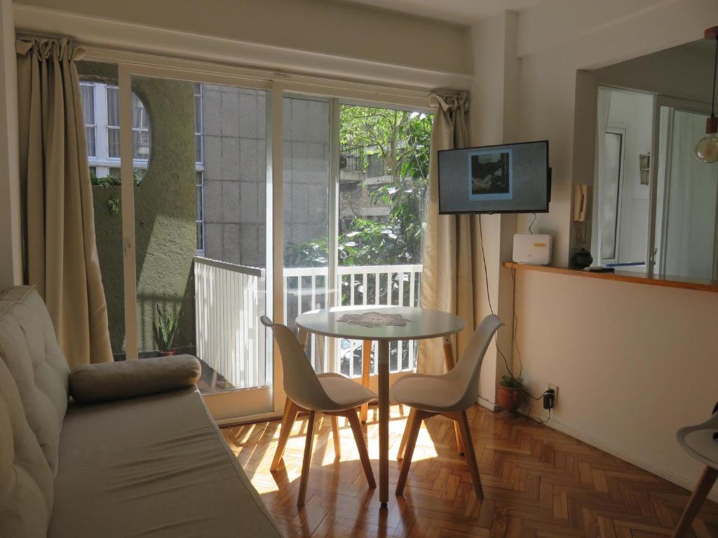 sala de estar con mesa y sillas y balcón en Oasis Palermo Soho en Buenos Aires