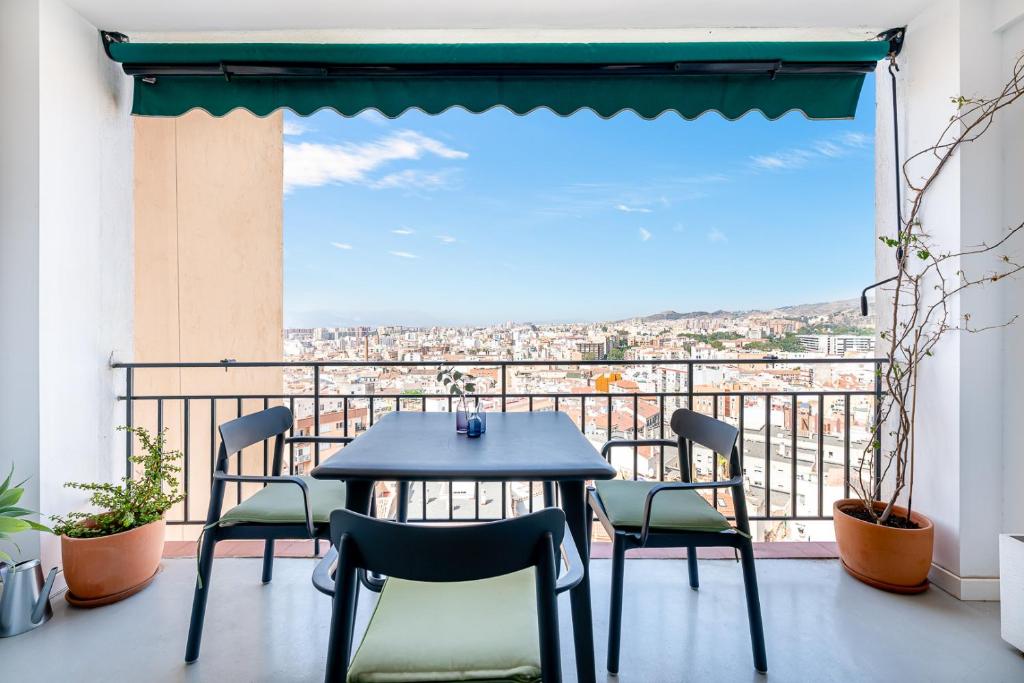 einen Tisch und Stühle auf einem Balkon mit Aussicht in der Unterkunft El balcón de los pintores in Málaga