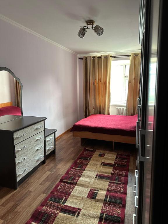 een slaapkamer met een bed, een dressoir en een raam bij Cozy one-bedroom apartment in the southern part of Bishkek (Уютная двухкомнатная квартира в южной части Бишкека) in Bisjkek