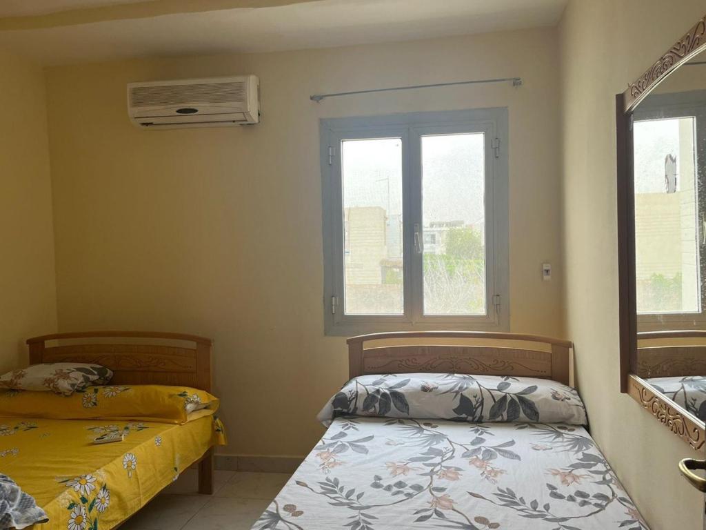 a bedroom with two beds and a window at villa tulipe in Ain Sokhna