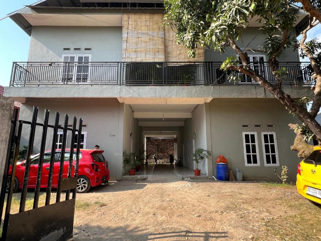 a red car parked in front of a house at Hotel O Kost Maharaja Near Maros in Makassar