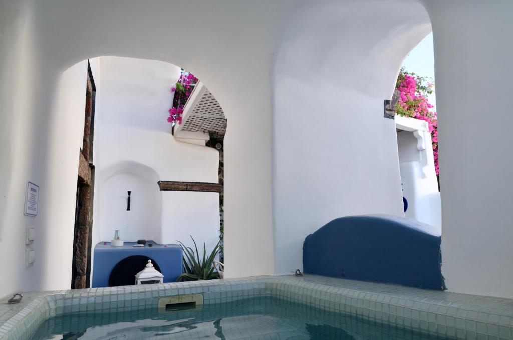 a bathroom with a swimming pool in a house at Villa Orpheus Santorini in Megalokhori