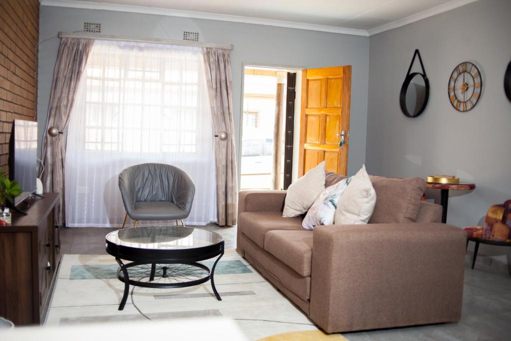 ein Wohnzimmer mit einem Sofa, einem Tisch und einem Stuhl in der Unterkunft The Cosy Crib in Palatswe
