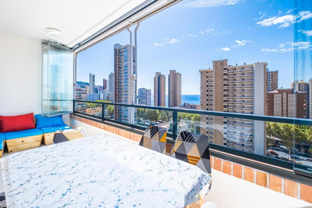 a balcony with a bed and a view of the city at Gemelos 23 - 10B Apartment Levante Beach in Benidorm