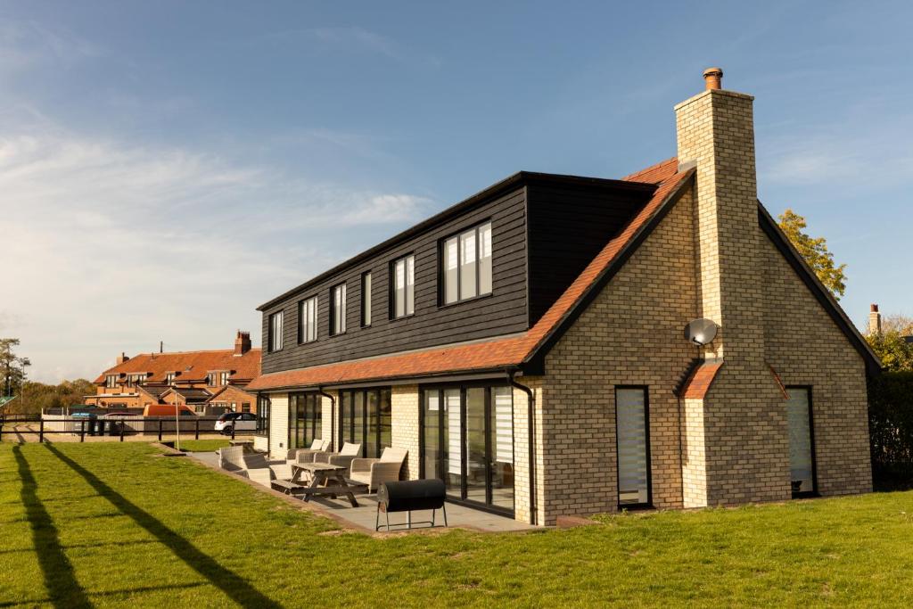 a brick house with a black roof at The Mayfair in Six Mile Bottom