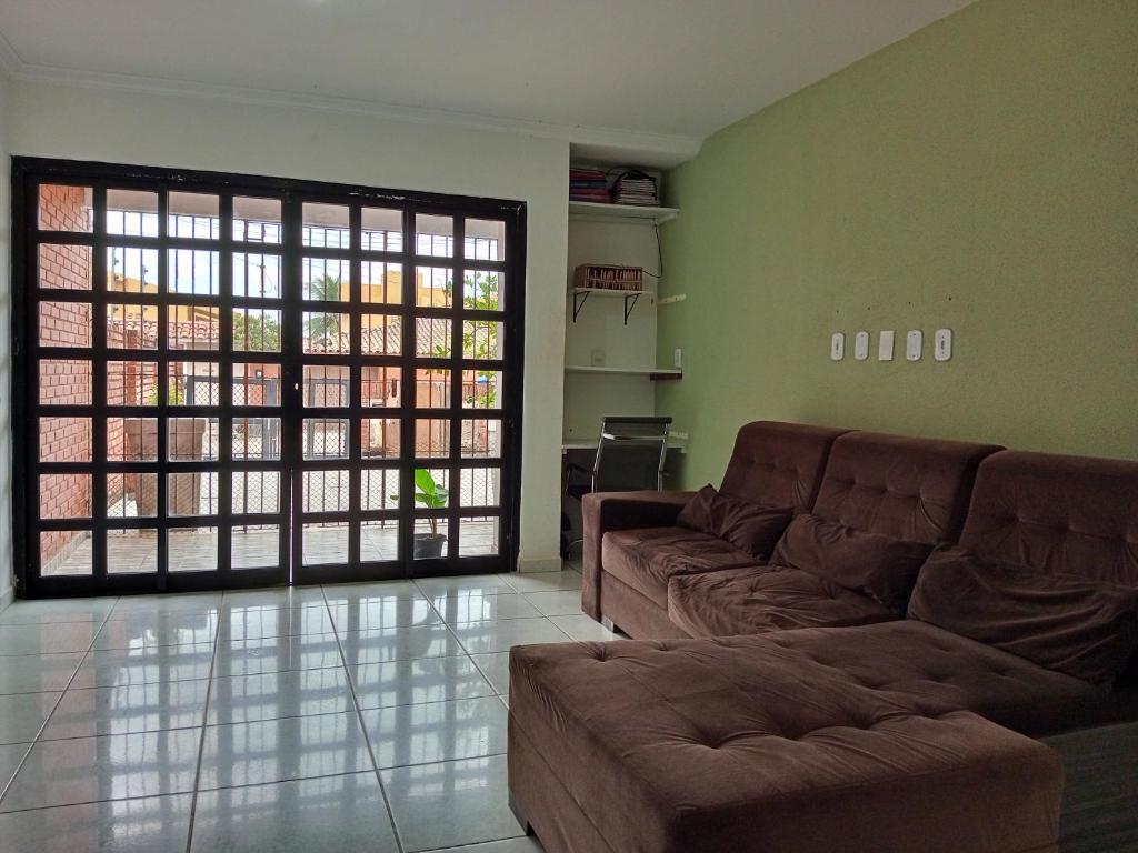 uma sala de estar com um sofá e uma grande janela em Um Paraíso no fim da rua em Barra de São Miguel