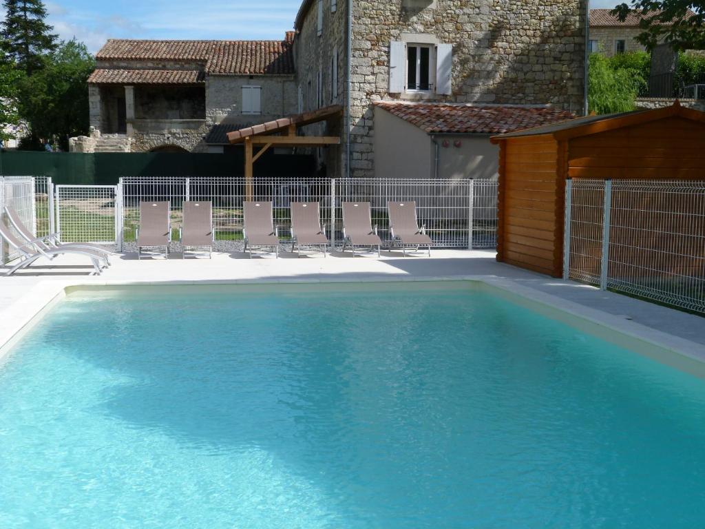une piscine avec des chaises et une maison dans l'établissement La Bastide des Borels, à Berrias Et Casteljau