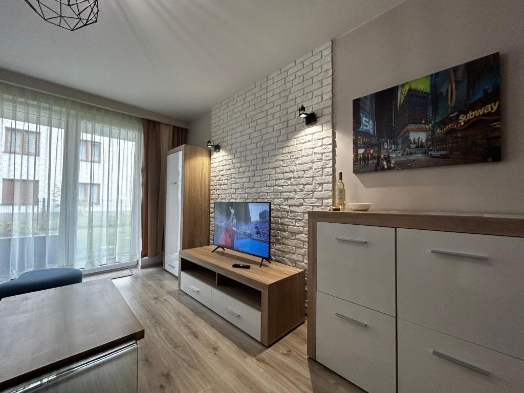ein Wohnzimmer mit einem Flachbild-TV auf einem Tisch in der Unterkunft M&M Apartament Glogera in Krakau