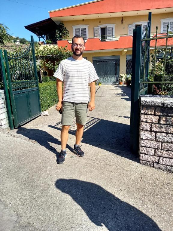 a man is standing in front of a gate at GuestHouseMantho in Gjirokastër