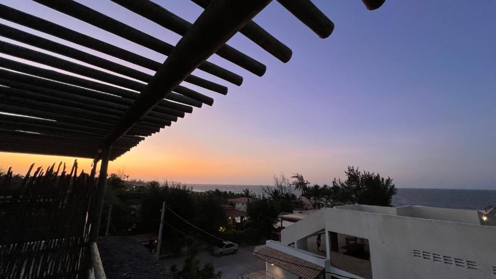 Una vista del atardecer desde el balcón de una casa. en Apartamento Beira Mar Preá, en Prea