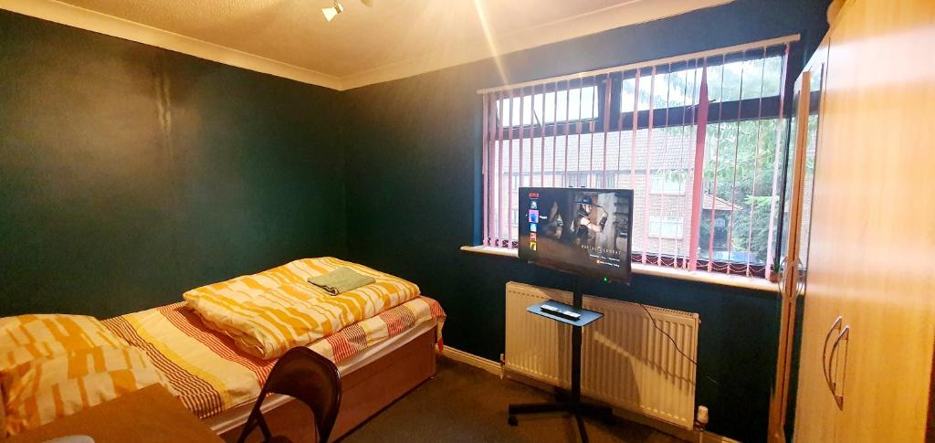 a bedroom with a bed and a tv in it at private room with free parking close to lake side in West Thurrock