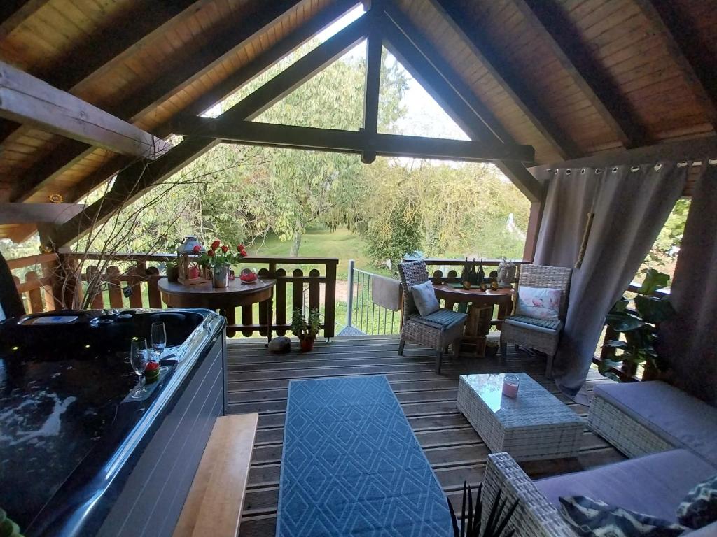 a screened in porch with a hot tub and a table at Gite avec SPA privé in Drulingen