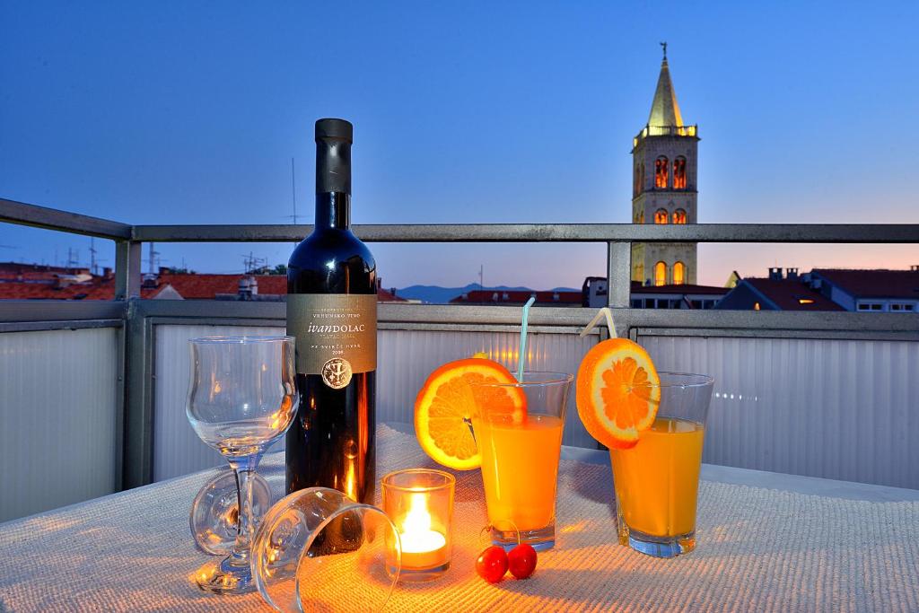 a bottle of wine and some glasses on a table at Sea Gate Studio in Zadar