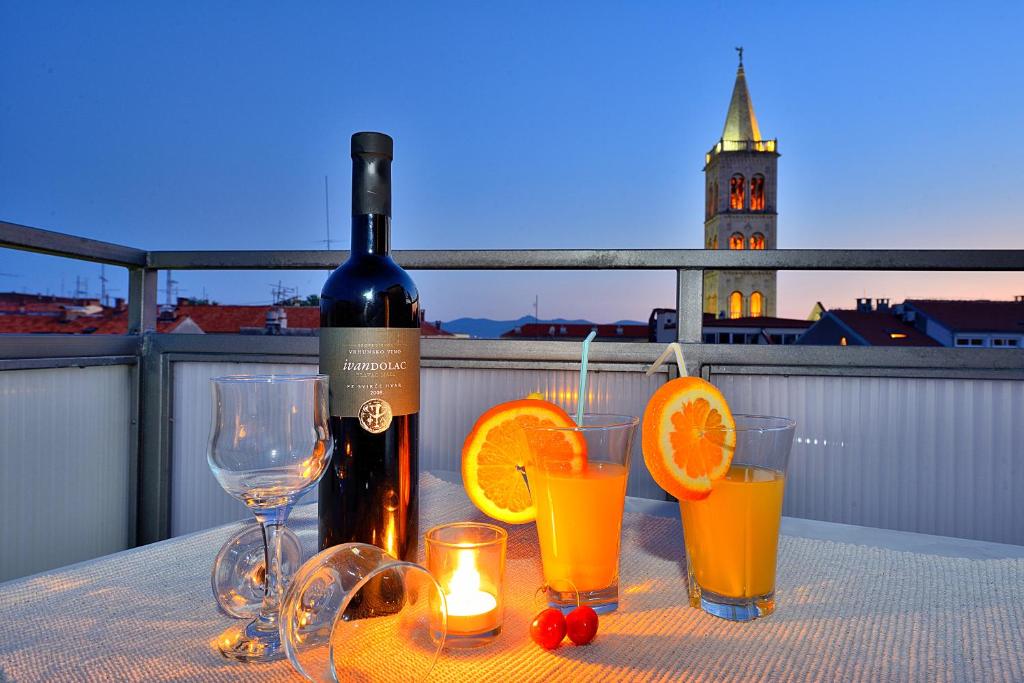 a bottle of wine and some glasses on a table at Sea Gate Studio in Zadar