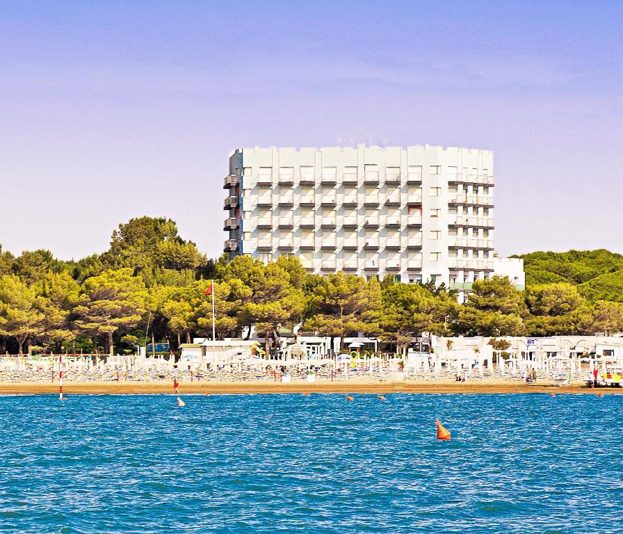 ein großes weißes Gebäude inmitten eines Wasserkörpers in der Unterkunft International Beach Hotel in Lignano Sabbiadoro