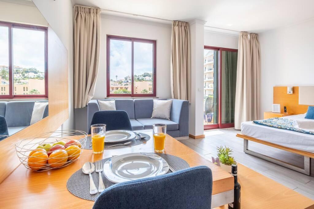 een woonkamer met een tafel en een bed bij Sarah's Apartment by GALMI in Caniço