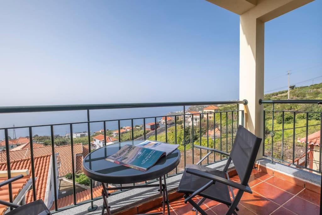 a table and chairs on a balcony with a view at Villa Sol da Candelária by GALMI in Ribeira Brava