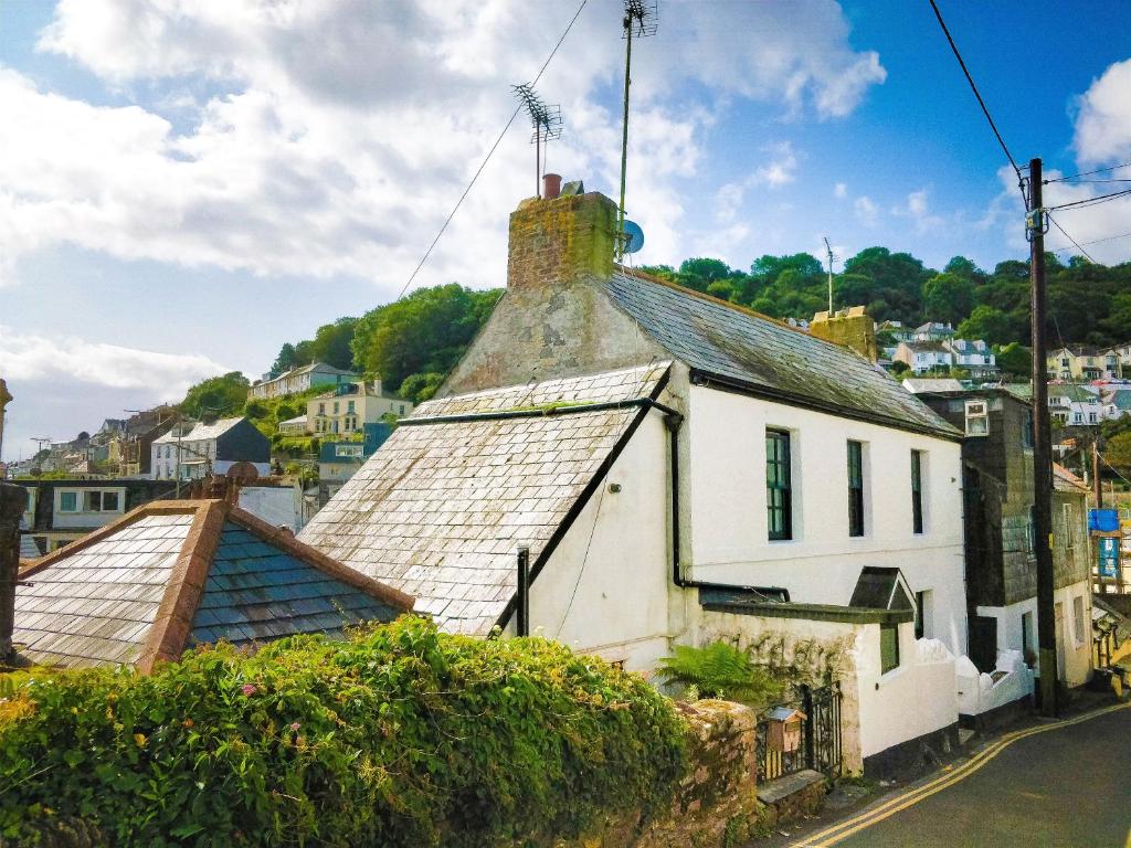 Una vieja casa blanca con techo en una calle en Jessamine: Restored fisherman's cottage close to Looe's harbour, en Looe