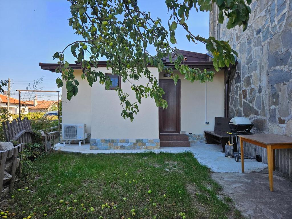 einen Hinterhof mit einem Grill, einem Tisch und einer Bank in der Unterkunft Къща за гости Елит (Guest House Elite) in Saparewa Banja