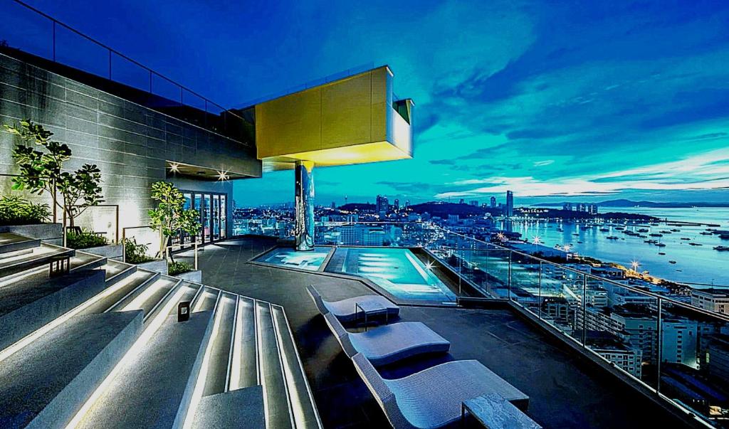 a building with a swimming pool with a view of a city at The Edge Central Infinity in Pattaya