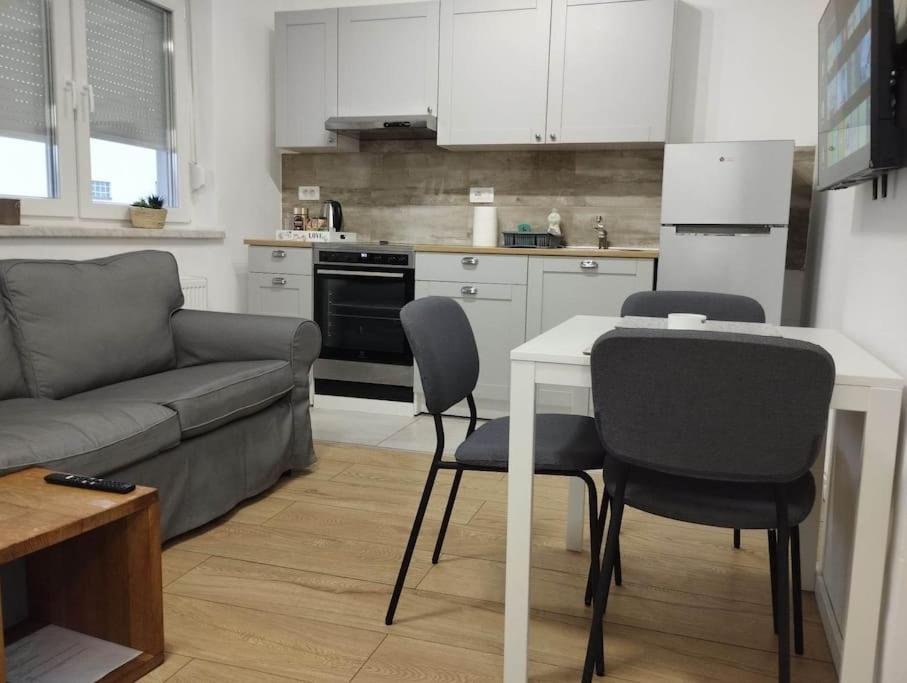 a kitchen with a couch and a table and chairs at Lovely flat, city center with free parking in Varaždin