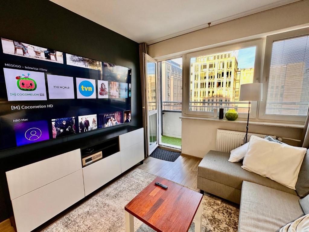 ein Wohnzimmer mit einem großen Flachbild-TV in der Unterkunft Gold 5 fast WiFi 1 Gbs big 85'TV Netflix HBO Disney+ in Warschau