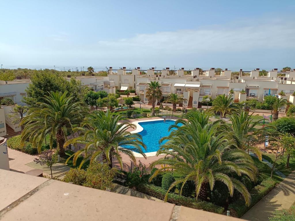 vista aerea di un resort con piscina e palme di coqueto y acogedor apartamento a Isla Cristina