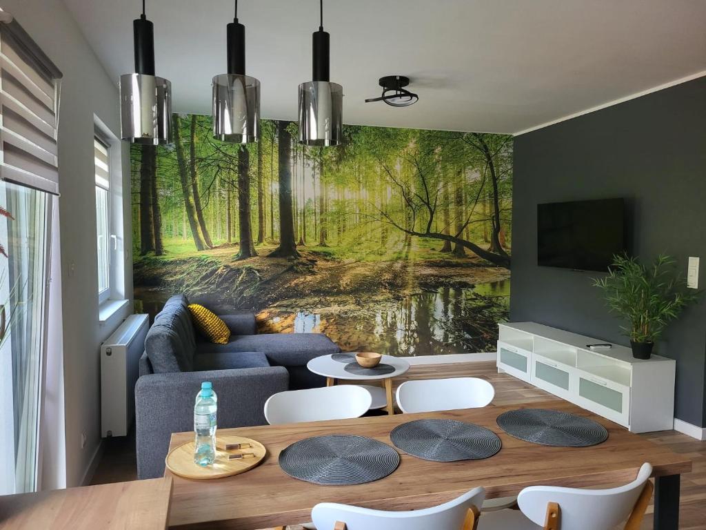 a living room with a painting of a forest at Apartamenty Dębowa in Milicz