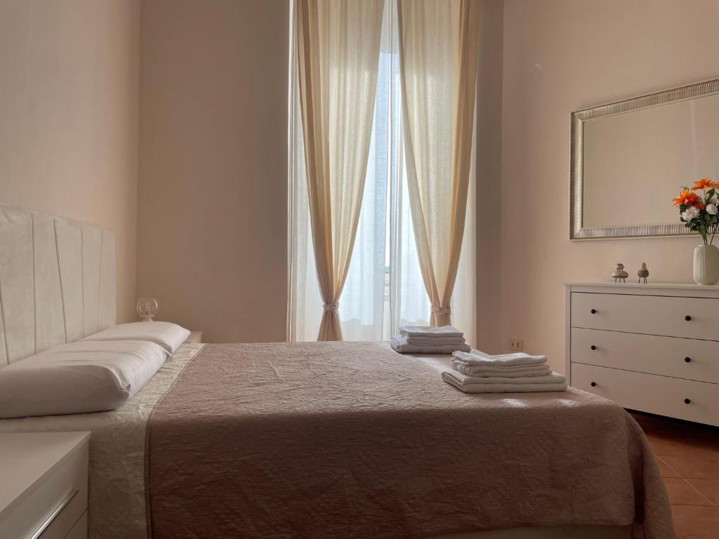 una camera con un letto, un comò e una finestra di Il Vicoletto nel centro storico di Frascati a Frascati