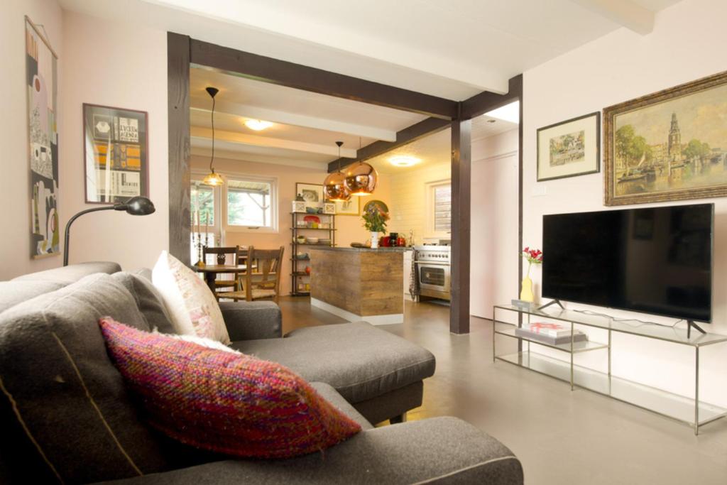 a living room with a couch and a tv at Boutique Studio ter Westenschouwen in Westenschouwen