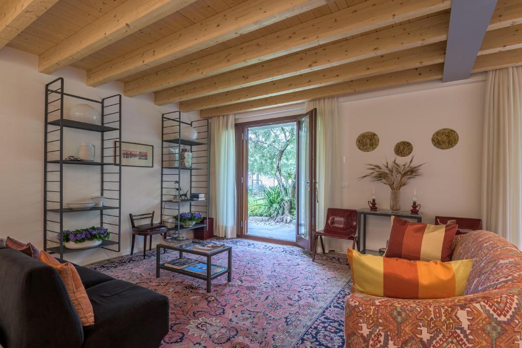 a living room filled with furniture and a large window at In Riva al Lago di Iseo Dependance Piano Terra in Marone