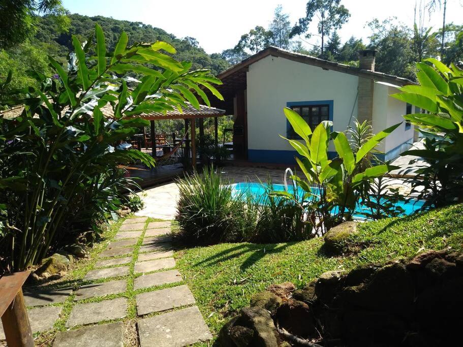 a garden with a house and a swimming pool at Vila Linda Flor in São José dos Campos