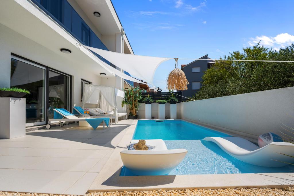 a backyard with a swimming pool and a house at Adriatic Paradise Villa in Vodice