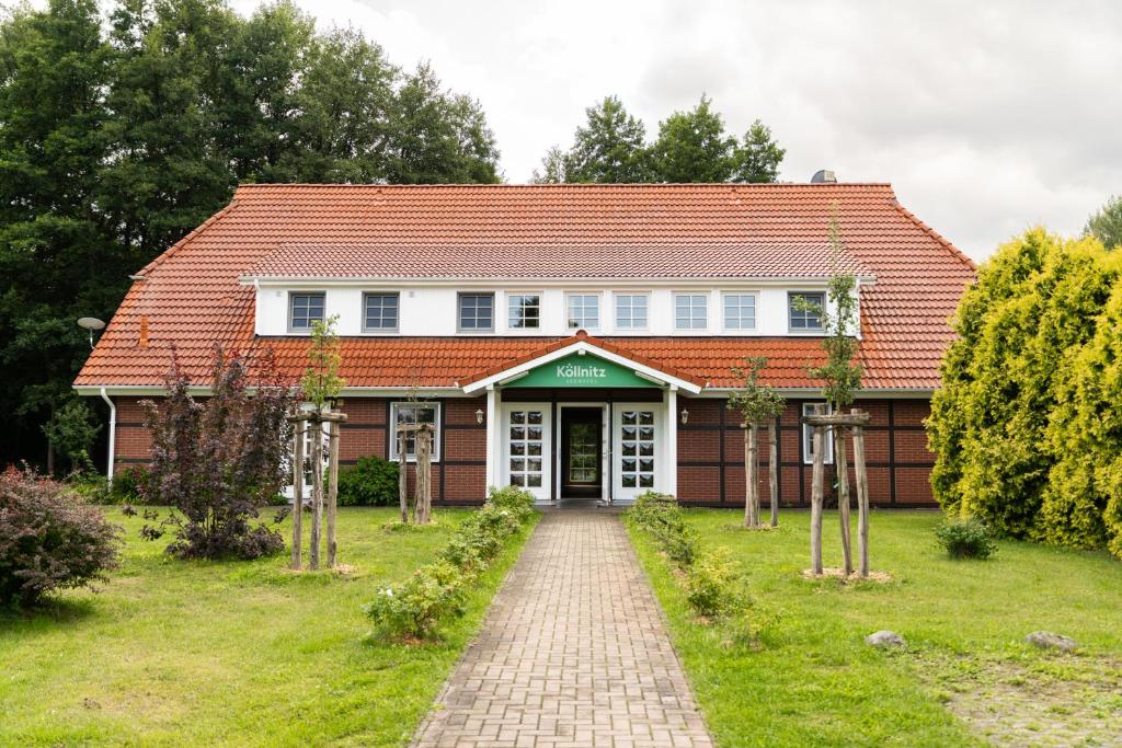 uma casa com um telhado vermelho e uma entrada de tijolos em Seehotel Köllnitz em Wochowsee