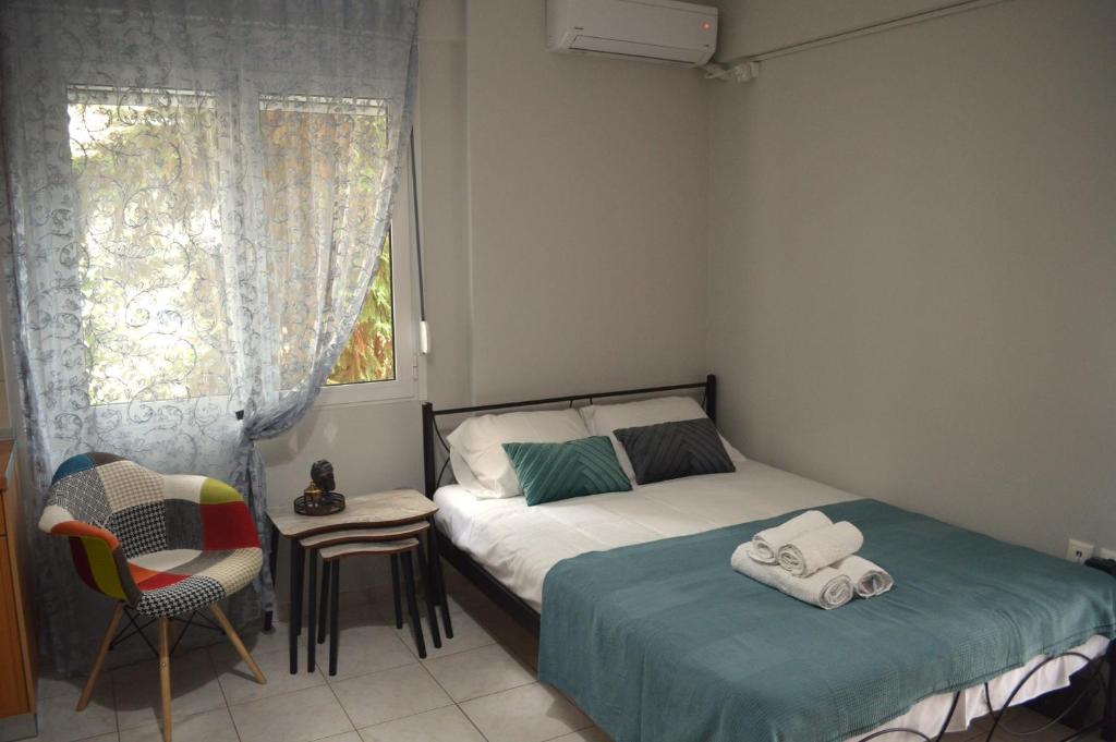 1 dormitorio con 1 cama, 1 silla y 1 ventana en Μοντέρνο Studio στο Κέντρο της Λάρισας en Larisa