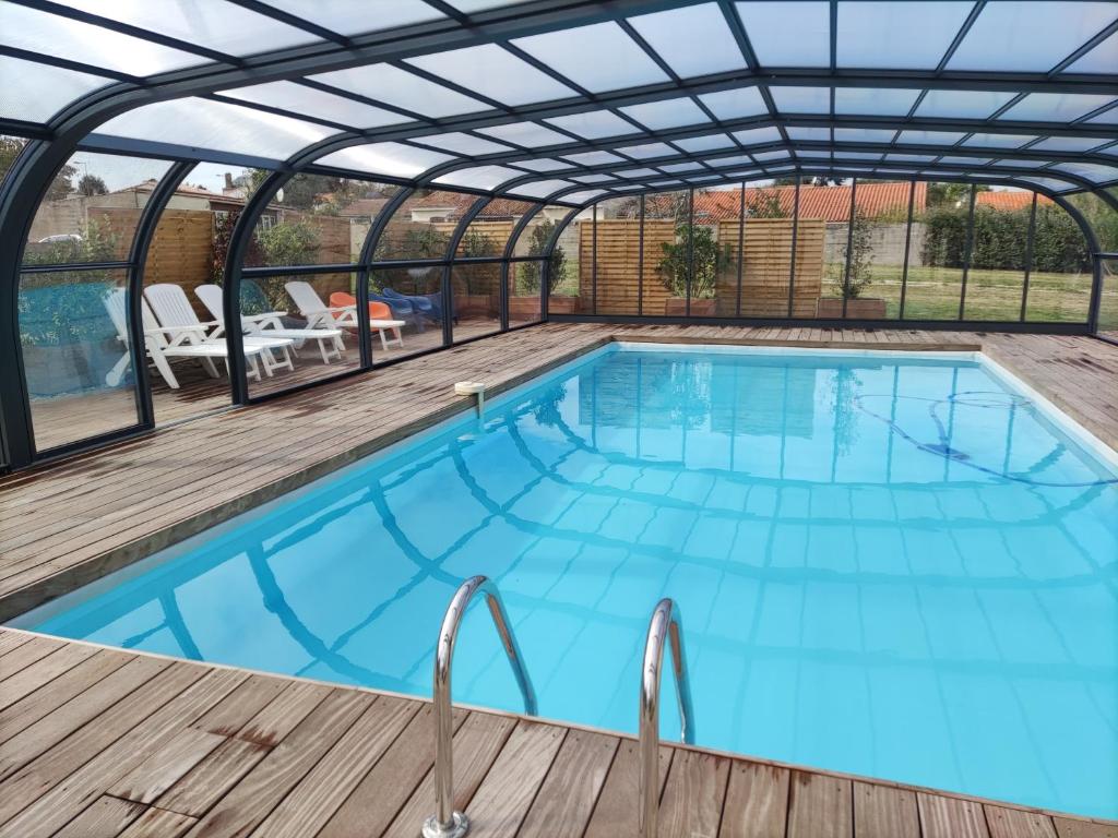 a swimming pool with a pergola and an outdoor swimming poolvisor at Maison avec piscine privée, proche plage in Avrillé