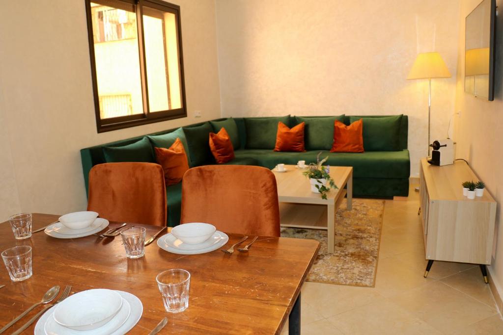 a living room with a green couch and a table at Magnifique Appartement Marrakech - 2 Chambre 2 Salle de Bains in Marrakech
