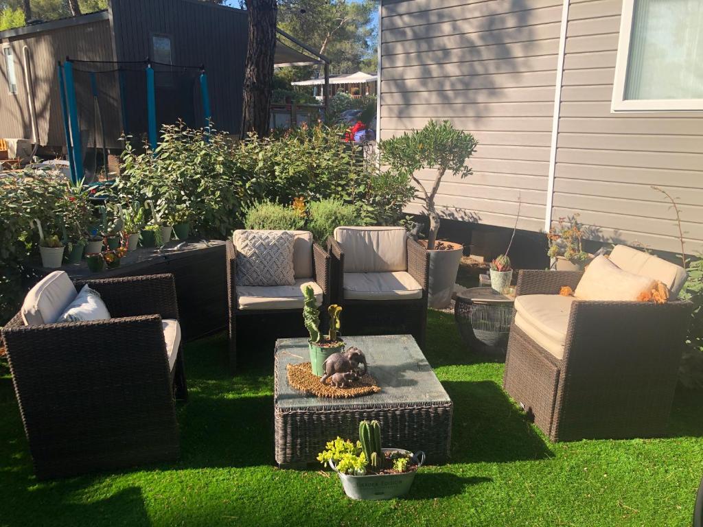 une cour avec des chaises, une table et un cactus dans l'établissement Mobilhome 6 personnes Camping Oasis Village 5 étoiles, à Puget-sur Argens