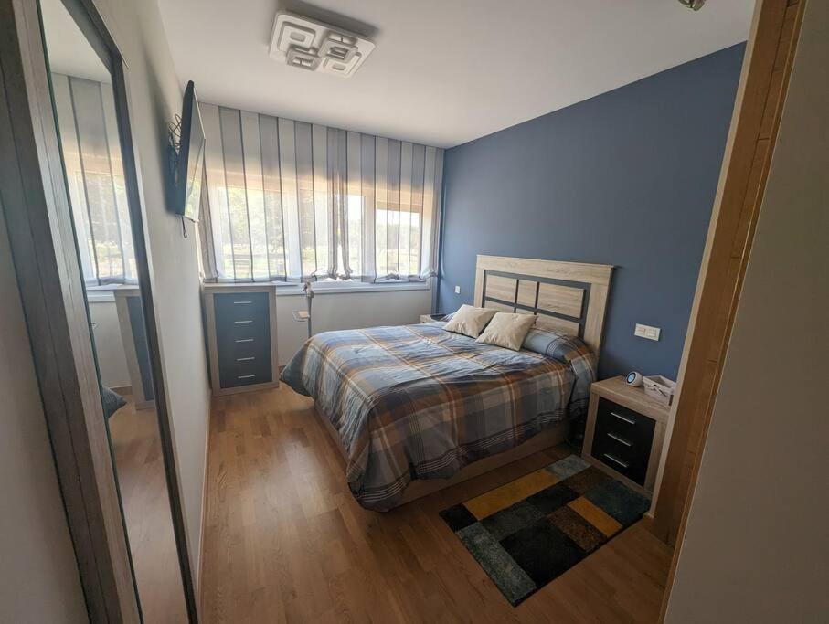 a bedroom with a bed with a blue wall at Piso completo y moderno, Burgos in Burgos