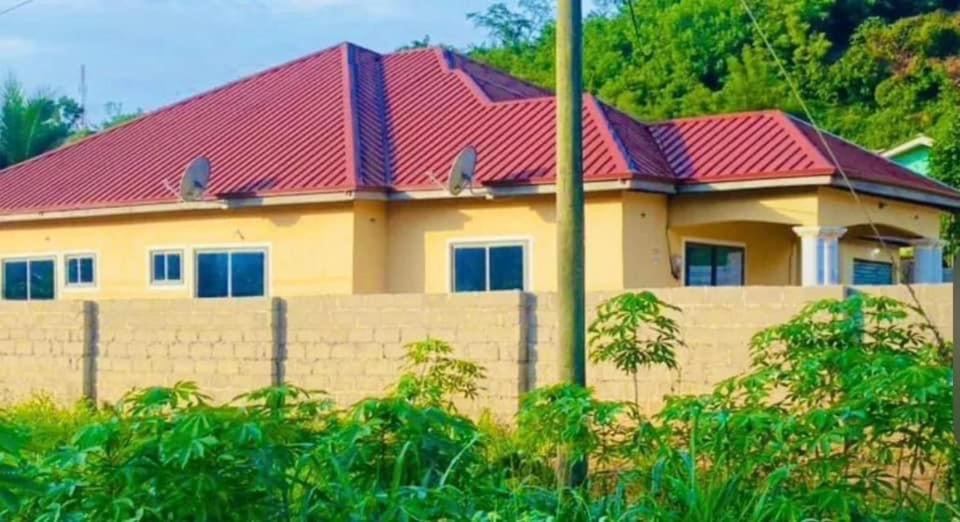 uma casa com uma cerca e um telhado vermelho em OLIVER COTTAGE GUESTHOUSE em Yamoransa