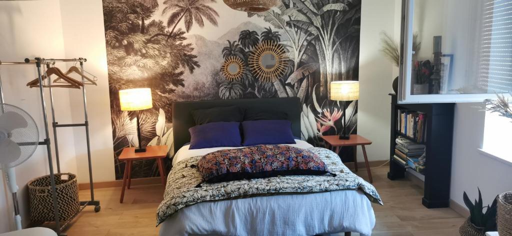 a bedroom with a bed with blue pillows and a wallpaper at Chez ROSE in Bruyères